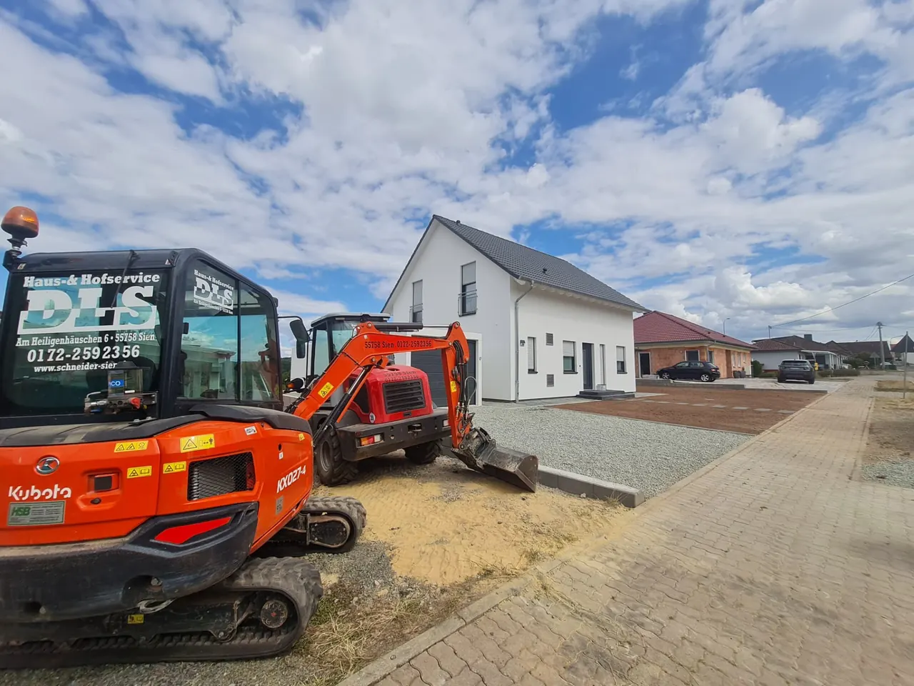 DLS Schneider bei Tiefbauarbeiten mit Baggern und eigenen Fahrzeugen vor einem Wohnhaus in der Region Sien