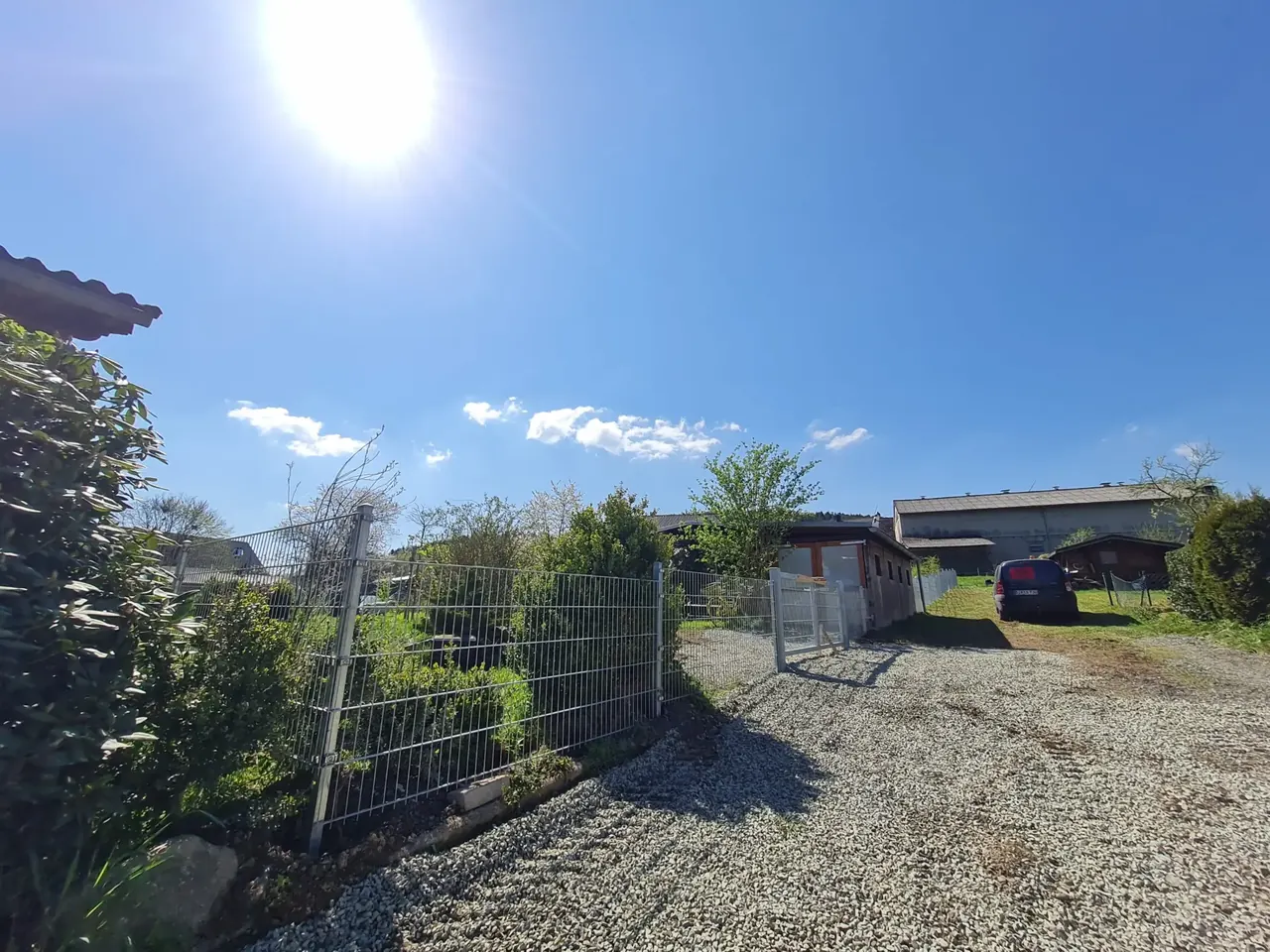 Zaunanlage mit Tor entlang einer neu angelegten Kiesfläche