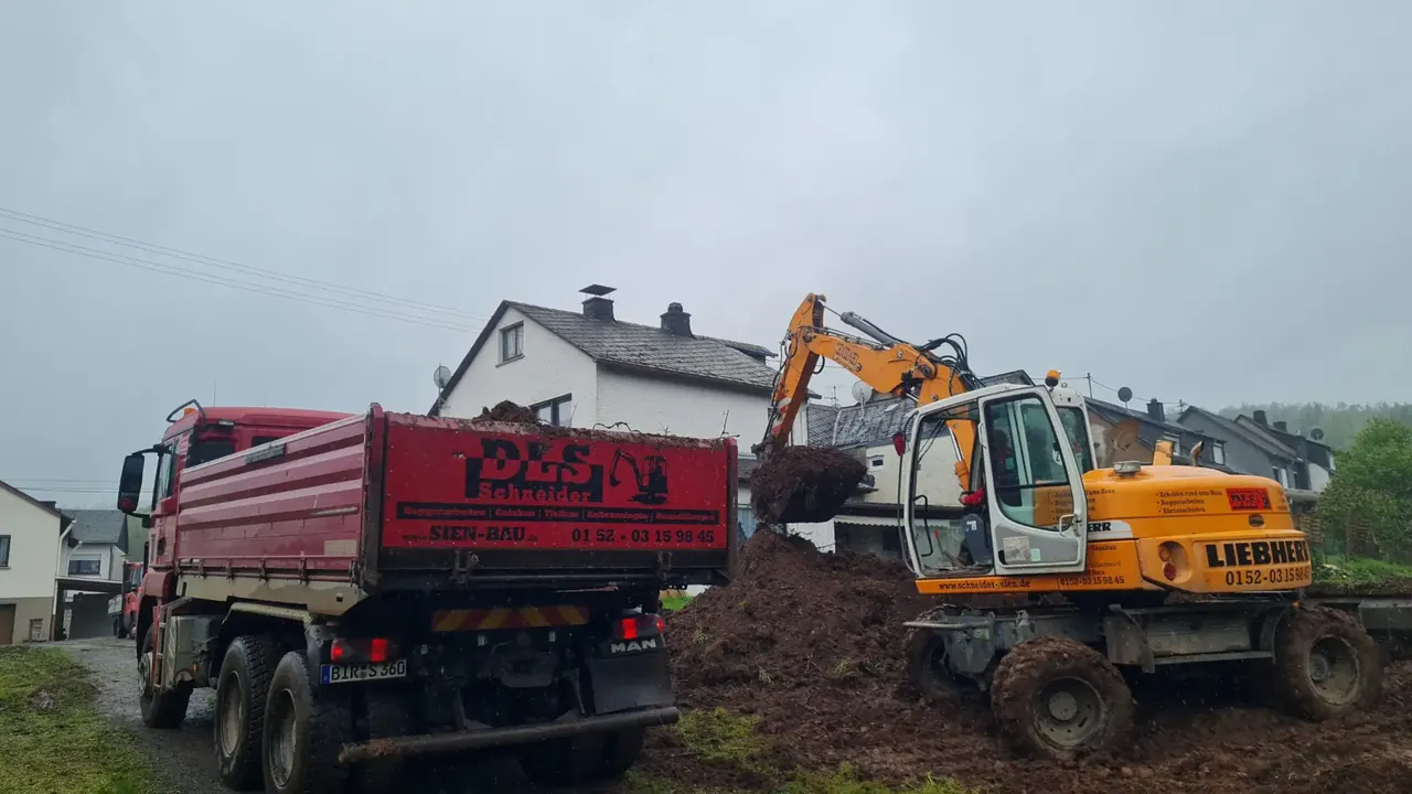 Mobilbagger belädt den Kipper von DLS Schneider mit Aushub